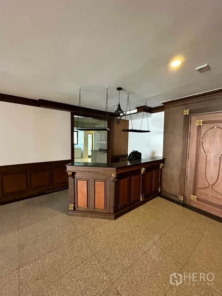 Condominium for rent in Bangkok - Built-in bar counter with pendant lights in a wood-paneled corner.