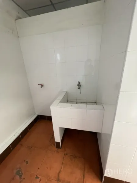 Warehouse for rent in Lam Luk Ka, Pathum Thani - Clean tiled utility area with sink inside the warehouse restroom.