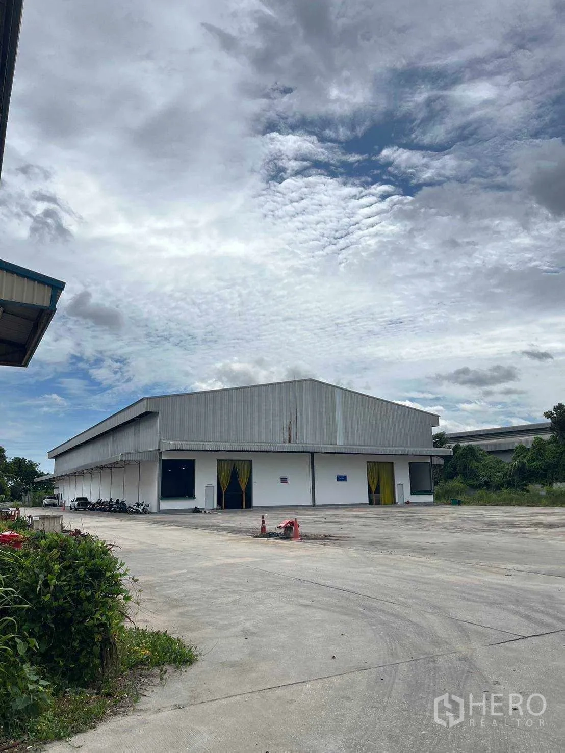 โรงงาน ขายในNikhom Phatthana, Rayong - ด้านหน้าโกดังพร้อมช่องโหลดสินค้าและลานจอดคอนกรีตกว้าง