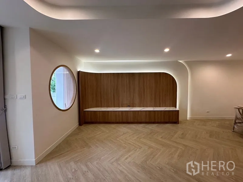 带办公室的家 出租在Khlong Toei, Bangkok - 弧形木饰背景墙、圆形窗与嵌灯设计。