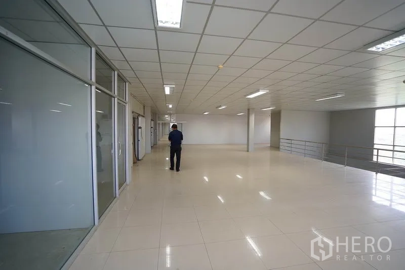 Factory for sale in Khlong Luang, Pathum Thani - Spacious open-plan mezzanine workspace with glass-walled offices and bright lighting.
