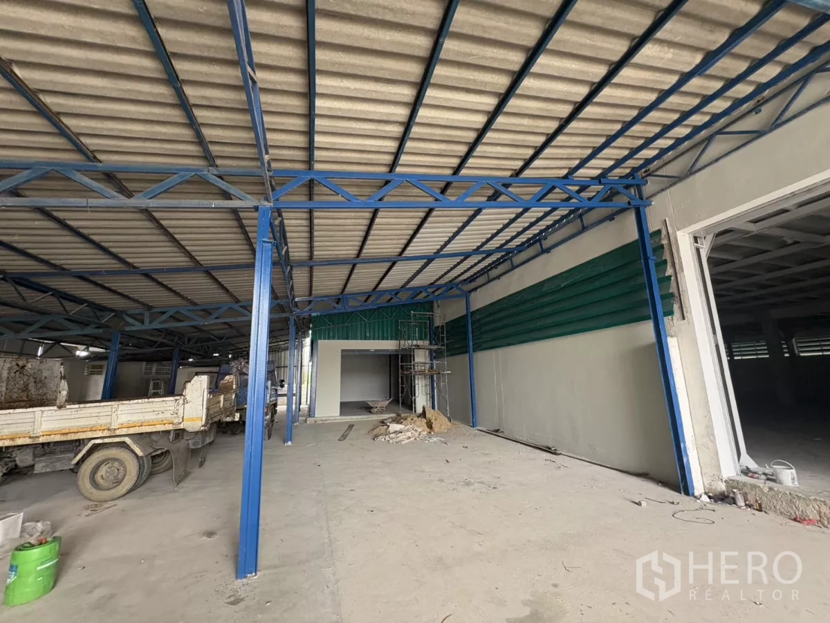 Factory for rent in Khlong Toei, Bangkok - Covered loading bay beside the workshop with blue steel structure.