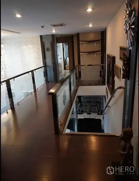 公寓 出租在Khlong Toei, Bangkok - 上层走廊，木地板与玻璃栏杆，可俯视下方客厅。