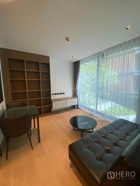 คอนโด ให้เช่าในWatthana, Bangkok - ห้องนั่งเล่นสว่าง โปร่ง ผนังกระจกเต็มบาน ชั้นวางบิวท์อิน โต๊ะทำงาน วิวสวน