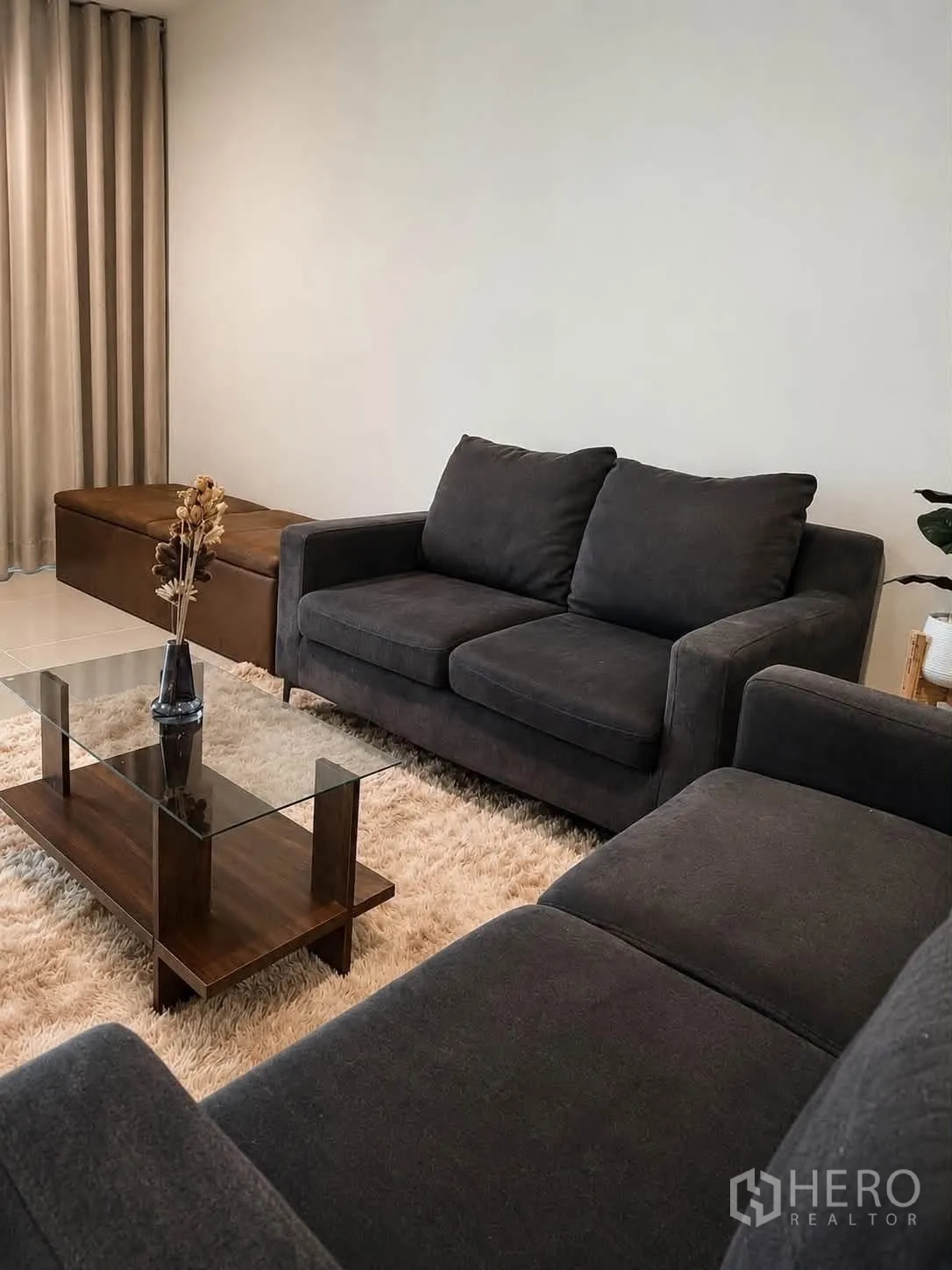 ทาวน์เฮาส์ for rent in Bang Phli, Samut Prakan - ห้องนั่งเล่นมีโซฟาสีเข้ม โต๊ะกลางกระจก และพรมขนนุ่ม.
