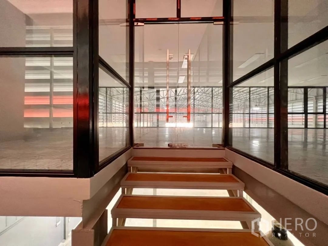 Warehouse for rent in Sai Mai, Bangkok - Glass-lined stair corridor leading to a mezzanine office overlooking the warehouse floor.