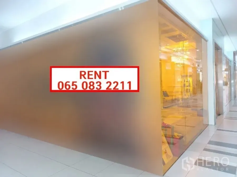 Retail Space for rent in Khlong Toei, Bangkok - Corner retail unit with floor-to-ceiling glass facade and bright interior lighting, for rent sign visible.