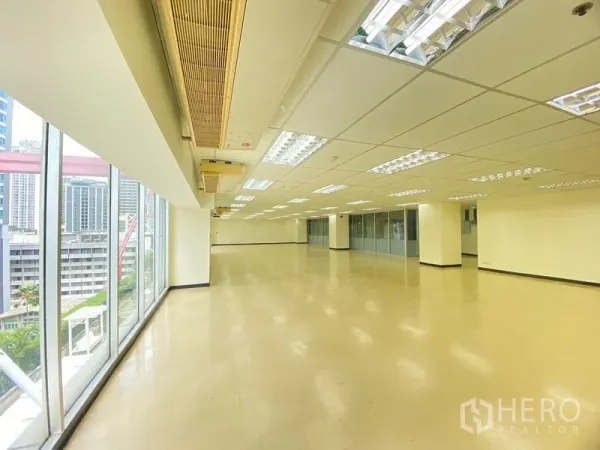 办公空间 出租在Watthana, Bangkok - 办公室内部，落地窗采光充足，可见城市景观。