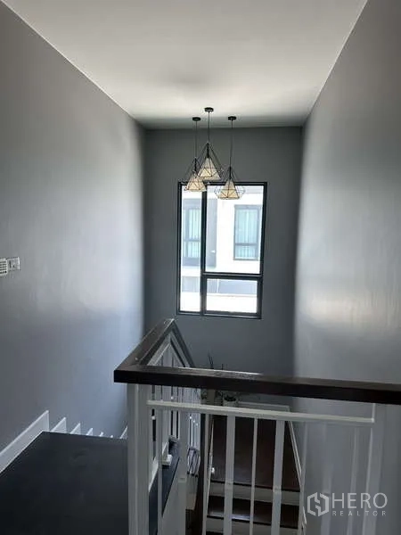 Detached House for sale in Lam Luk Ka, Pathum Thani - Stairwell with modern pendant lights and a tall window.