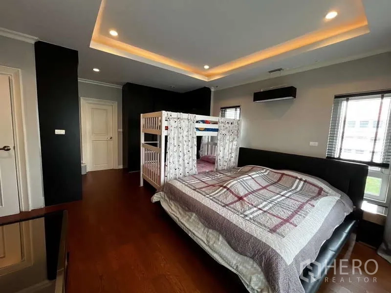 独立式住宅 出租在Prawet, Bangkok - 家庭卧室，配双人床、上下铺与灯槽天花。