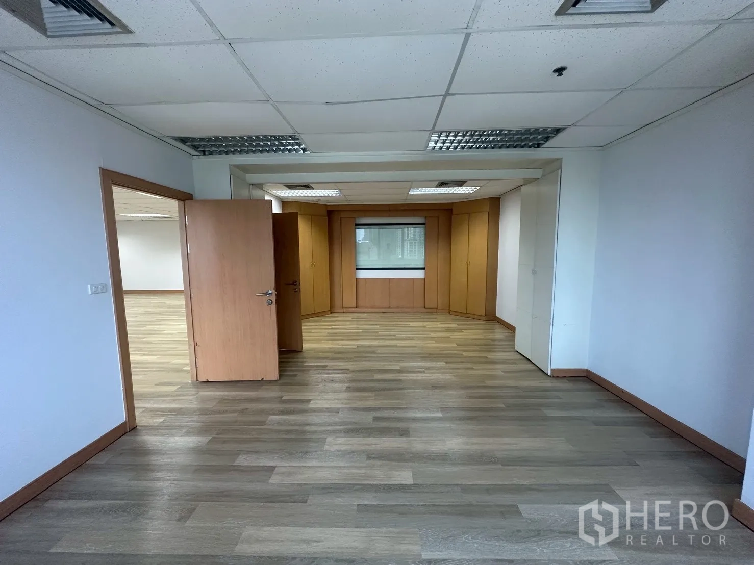 Office Space for rent - Manager room with built-in cabinetry, window, and wood flooring.