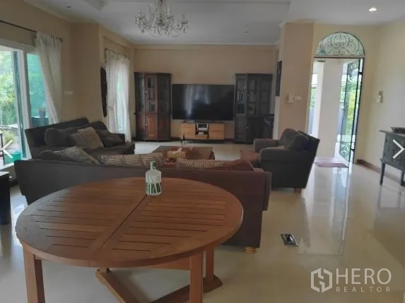 บ้าน ให้เช่าในHuai Khwang, Bangkok - ห้องรับแขกชั้นล่างพร้อมโซฟาหลายชุดและประตูกระจกบานเลื่อน