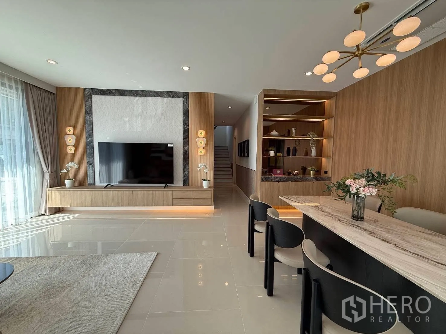 独栋房屋 for rent in Bang Phli, Samut Prakan - 客厅电视特色墙、内置柜与餐区吊灯。