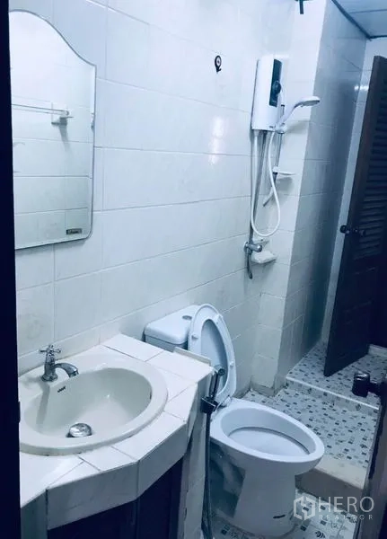联排别墅 出租在Watthana, Bangkok - 卫生间配淋浴、热水器与瓷砖墙面。