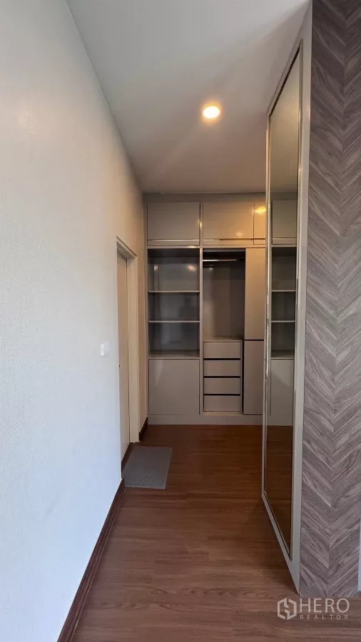 Detached House for rent or sale in Saphan Sung, Bangkok - Dressing area featuring mirrored wardrobe doors and open shelves along a narrow hallway.