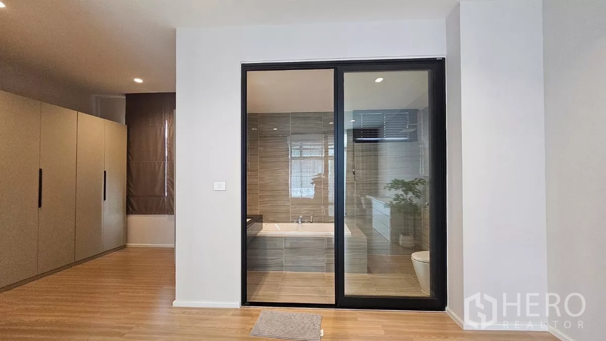 Townhouse for rent in Saphan Sung, Bangkok - Sliding glass doors from the bedroom reveal an ensuite bathroom with bathtub.
