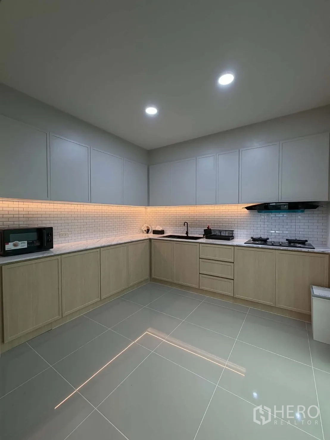 ทาวน์เฮาส์ for rent in Bang Phli, Samut Prakan - ครัวกว้างพร้อมตู้ลอย ผนังอิฐขาว และไฟส่องใต้ตู้