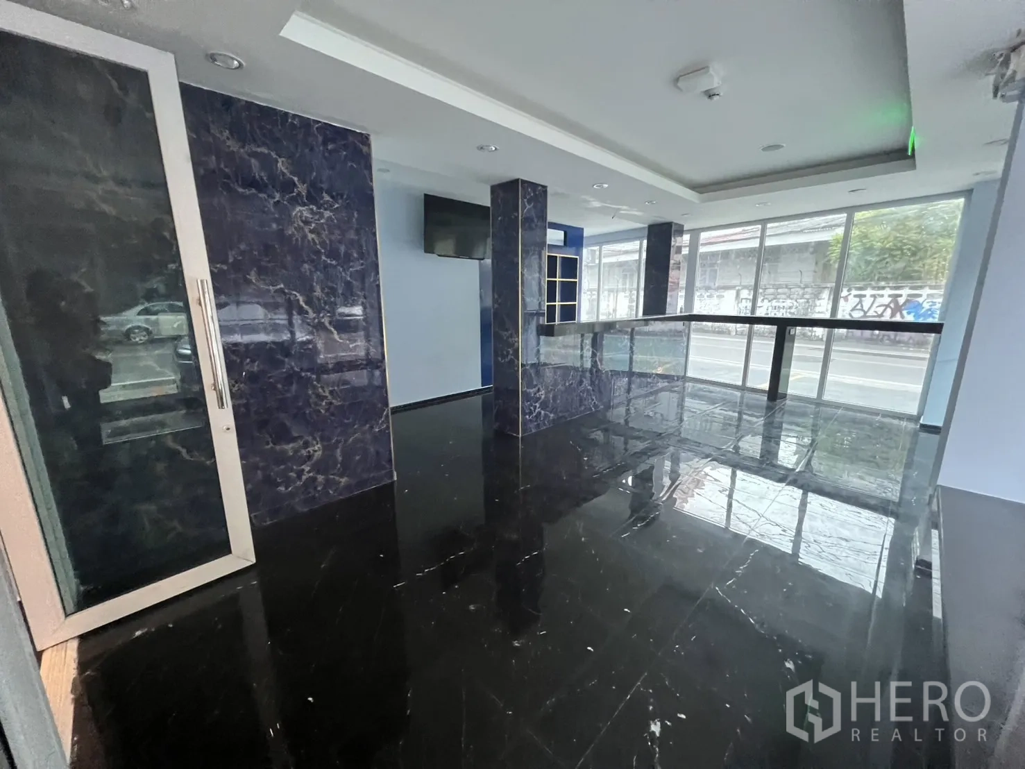 Retail Space for rent in Khlong Toei, Bangkok - Bright corner of the retail unit with wraparound windows and polished stone finishes.