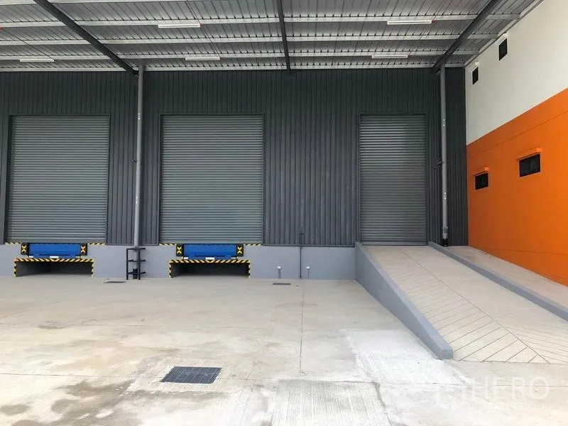 Factory for rent in Wang Noi, Phra Nakhon Si Ayutthaya - Loading area with three bays, dock levelers, and a truck ramp under a canopy.