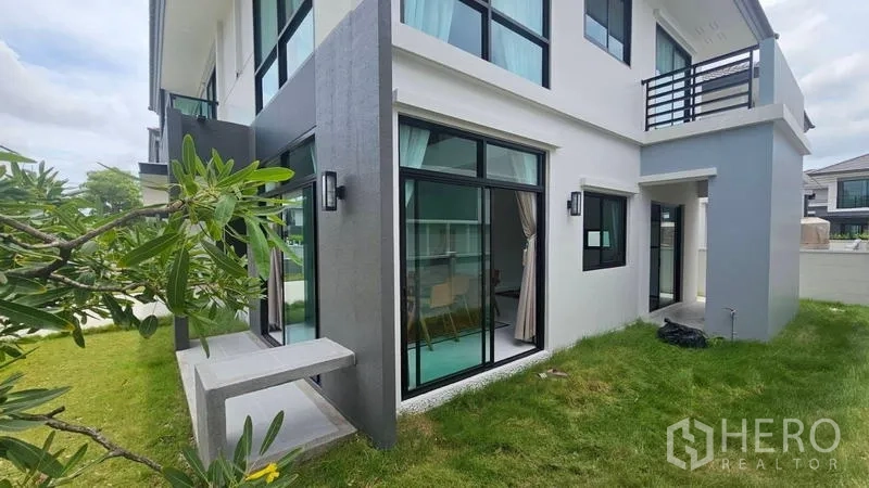 Detached House for rent in Bang Bo, Samut Prakan - Corner garden with sliding glass doors and large windows.