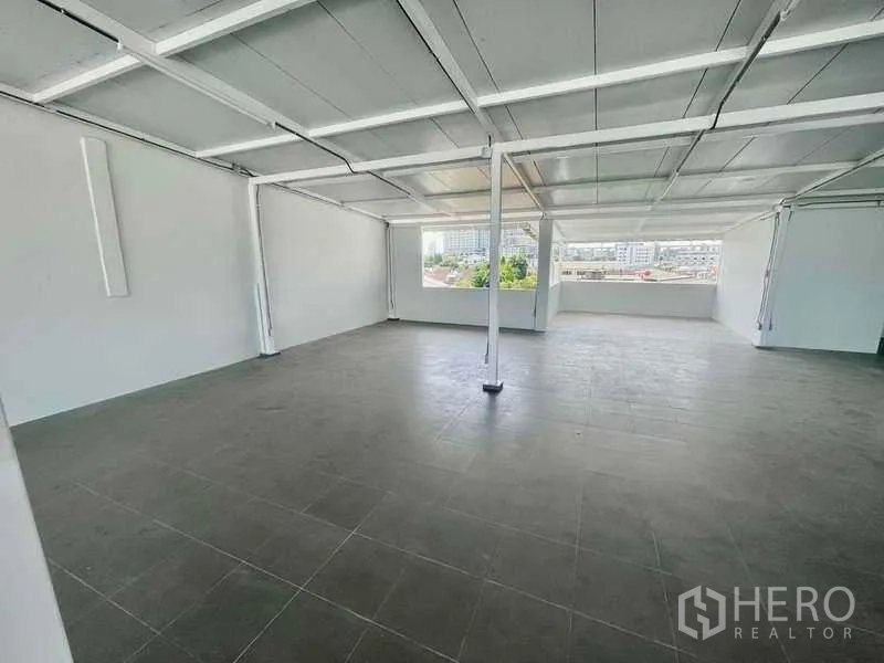 Home Office for rent or sale in Bang Kapi, Bangkok - Wide column‑free floor with windows on both sides, tiled surface, and metal ceiling.