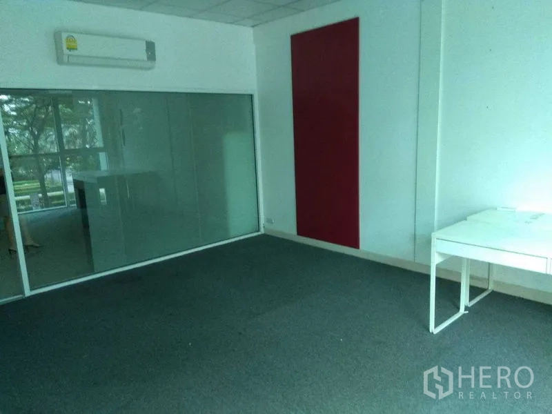 Retail Space for rent in Huai Khwang, Bangkok - Carpeted showroom or office with a frosted glass wall and red accent panel.
