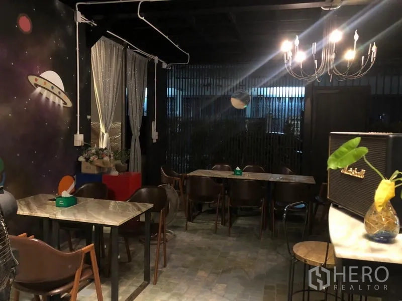 Retail Space for rent in Khlong Toei, Bangkok - Cafe-style dining area with chandelier lighting and a space-themed mural wall.