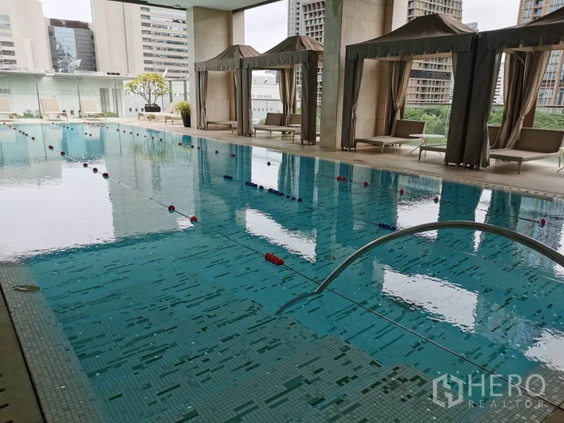 Condominium for rent in Pathum Wan, Bangkok - Large covered lap pool with cabanas and sun loungers.