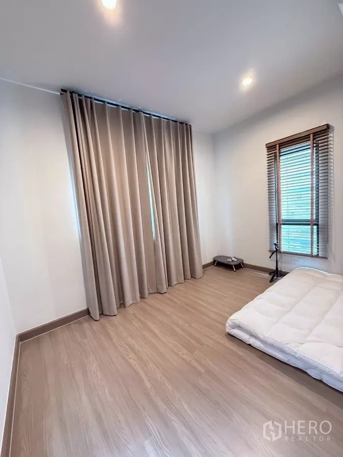 Detached House for rent in Lat Krabang, Bangkok - Secondary bedroom with large window, blinds and wood-look flooring.