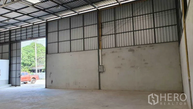 货栈 出租在Pathum Thani - 仓库内部，高挑钢结构屋顶，混凝土地面，带宽幅装卸大门。