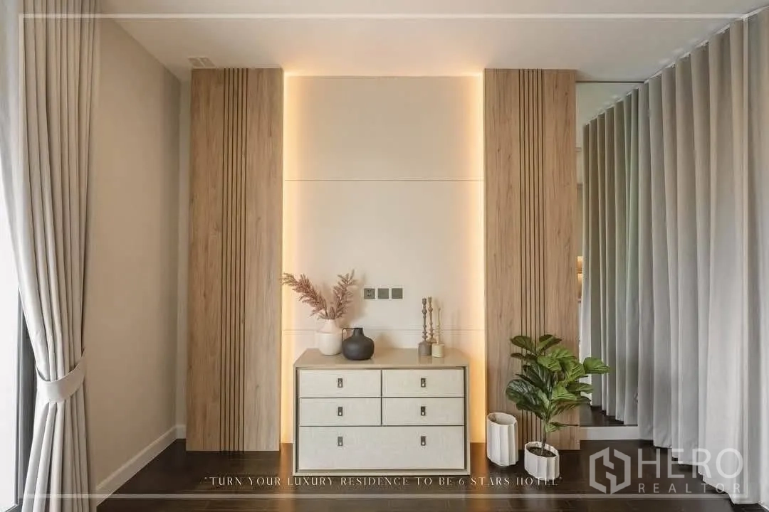บ้านเดี่ยว for rent or sale in Suan Luang, Bangkok - ผนังเน้นแสงวอร์มพร้อมตู้ลิ้นชักและกระถางต้นไม้