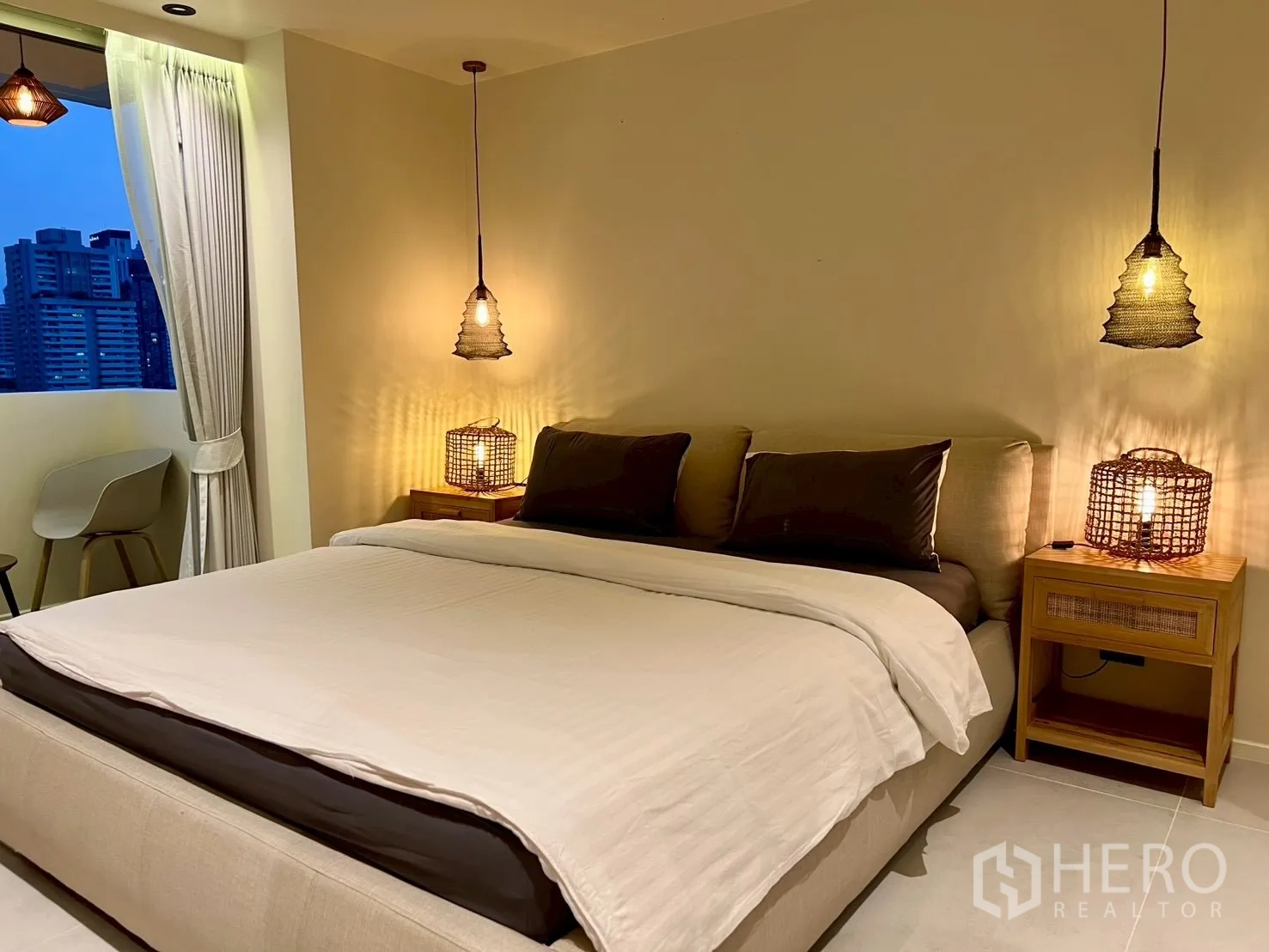 คอนโด for sale in Watthana, Bangkok - ห้องนอนยามค่ำพร้อมโคมไฟแขวน เตียงคิง และวิวสกายไลน์