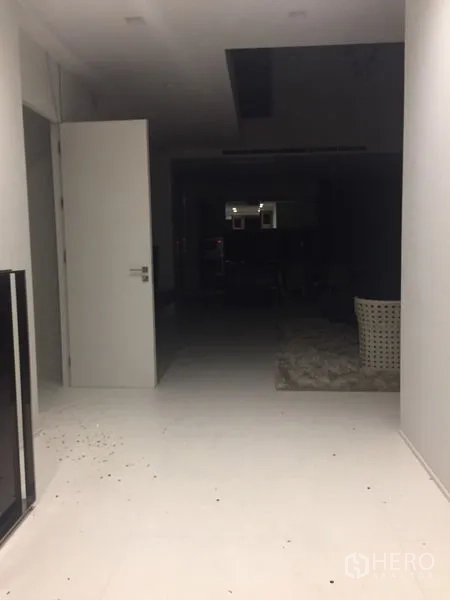 Detached House for rent in Wang Thonglang, Bangkok - Wide hallway with white tiles and an open door leading toward a lounge area.