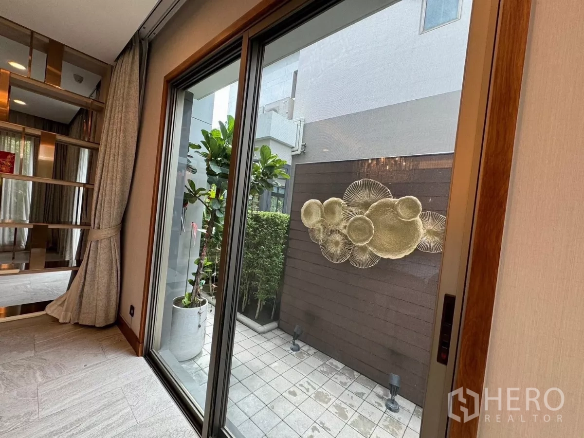 บ้าน ให้เช่าในPrawet, Bangkok - ประตูกระจกเปิดสู่ลานกระเบื้อง ผนังตกแต่งและกระถางต้นไม้
