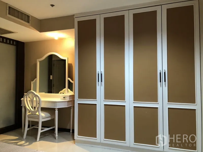 Condominium for rent in Khlong Toei, Bangkok - Built-in wardrobe and dressing table with mirror in the bedroom.