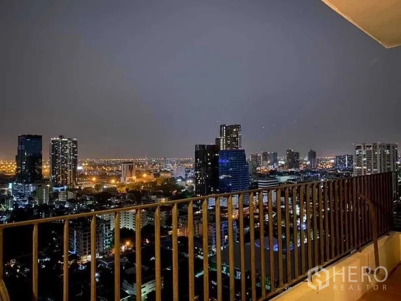 Condominium for rent in Watthana, Bangkok - High-floor balcony railing overlooking Bangkok’s glittering night skyline.