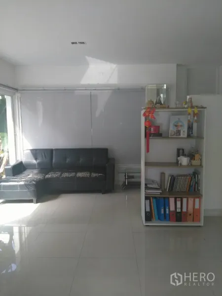 公寓 出租在Pathum Wan, Bangkok - 明亮客厅，亮面瓷砖地板，黑色转角沙发与白色置物架，大窗采光