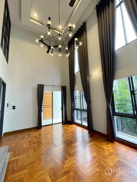 บ้าน ให้เช่าในBang Na, Bangkok - ห้องเพดานสูงพร้อมโคมระย้า ผ้าม่านสูง และประตูระเบียง