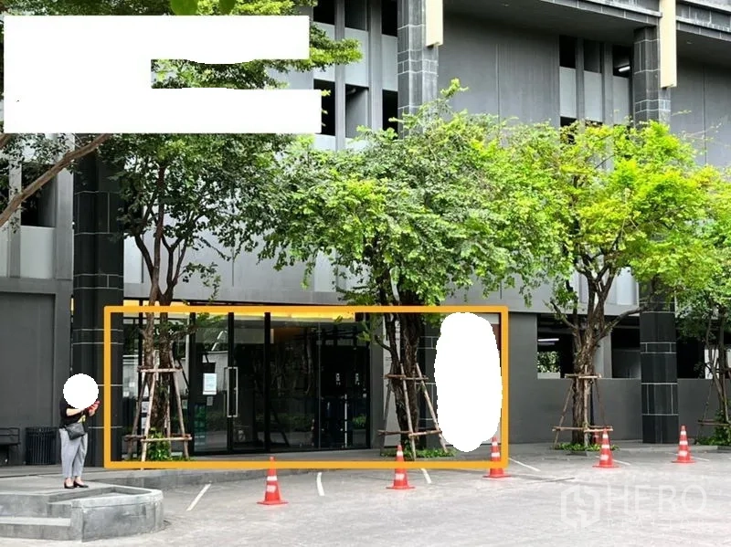 พื้นที่ขายปลีก ให้เช่าในWatthana, Bangkok - ด้านหน้าพื้นที่ค้าปลีกชั้นล่าง กระจกเต็มบาน มีต้นไม้ร่มรื่นและช่องจอดรถหน้าอาคารสไตล์โมเดิร์น