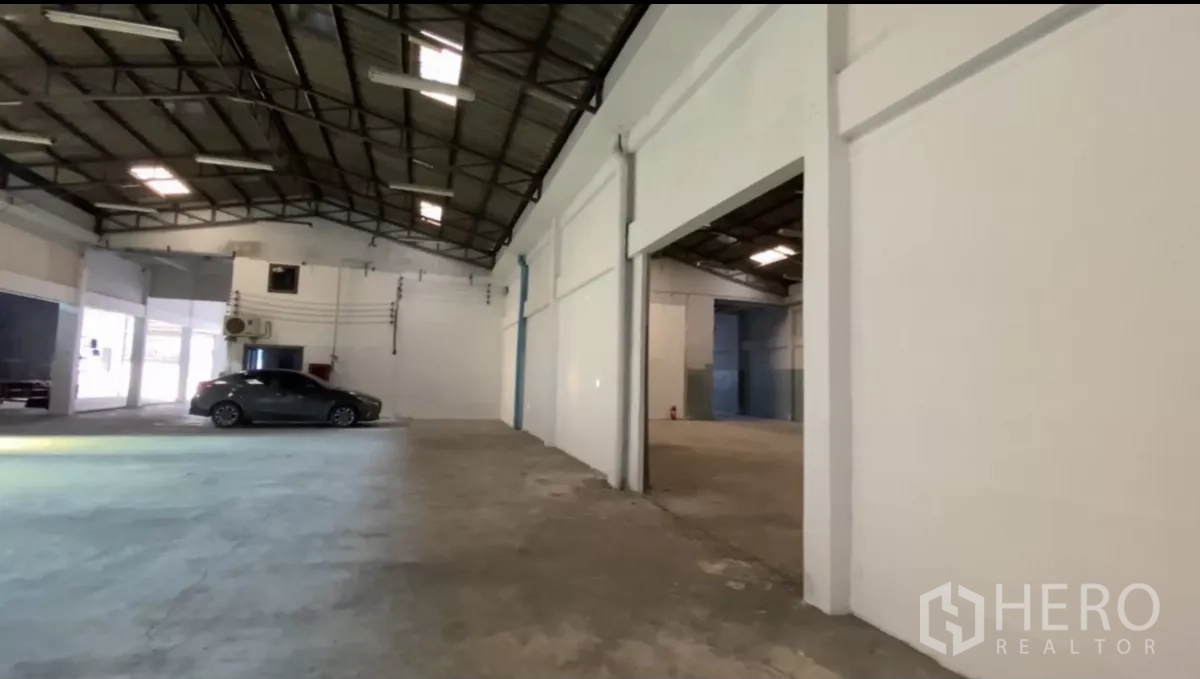 Factory for rent in Bang Phli, Samut Prakan - Large factory space with high ceiling, concrete floor and car parking area.