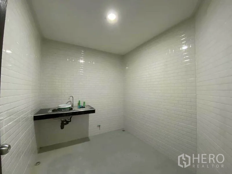 Retail Space for rent in Khlong Toei, Bangkok - Utility or pantry room with sink and white subway tiles.