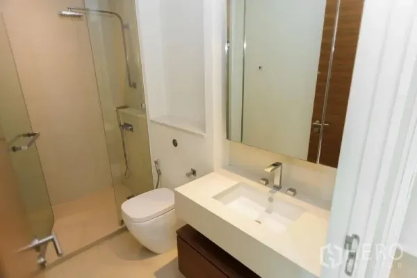 公寓 出售在Khlong San, Bangkok - 现代化浴室，玻璃淋浴间、挂墙式马桶与时尚台盆。