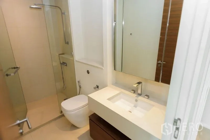 公寓 出售在Khlong San, Bangkok - 现代化浴室，玻璃淋浴间、挂墙式马桶与时尚台盆。