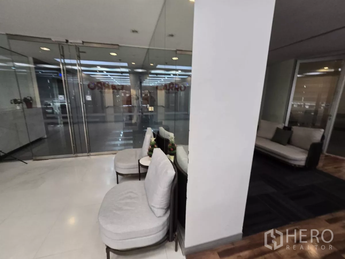 สำนักงาน ให้เช่าในWatthana, Bangkok - มุมรอรับแขกเก้าอี้นุ่มข้างประตูกระจกคู่และพรมสีเข้ม