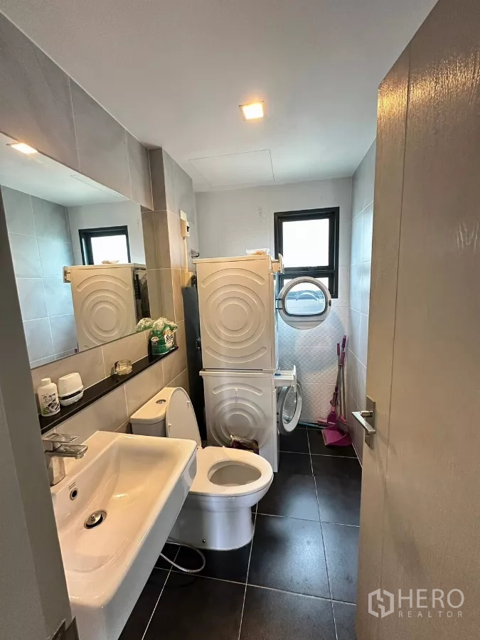 Detached House for rent in Saphan Sung, Bangkok - Guest bathroom with toilet, sink and stacked washer and dryer.