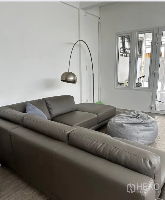 联排别墅 for rent in Sathon, Bangkok - 起居室配转角沙发、落地灯与窗户。