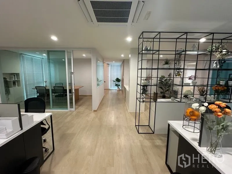 Warehouse for sale in Pathum Thani - Hallway with display shelving and glass-partitioned meeting rooms in the office area.