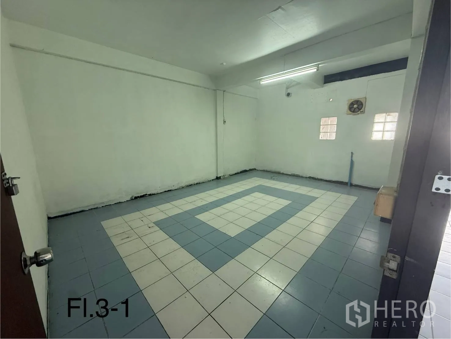 Shophouse for rent in Bang Na, Bangkok - Third-floor enclosed room featuring patterned tiles, glass-block windows, and a wall exhaust fan.
