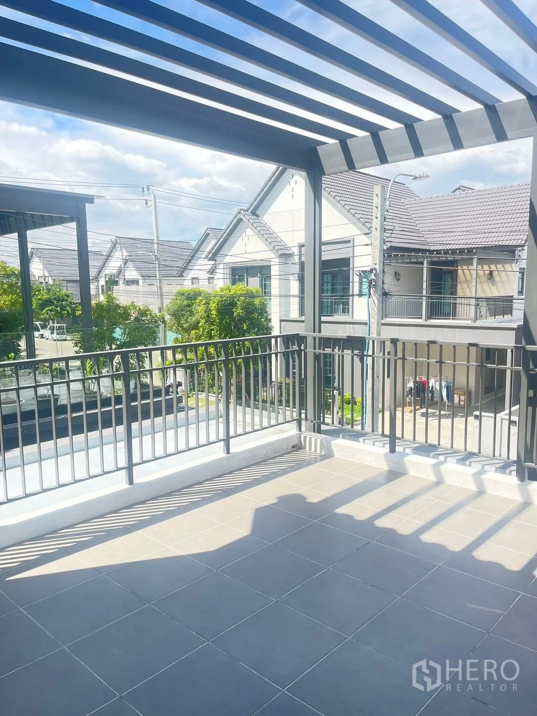 Detached House for rent in Bang Phli, Samut Prakan - Upper-floor terrace with tiled floor and pergola roof overlooking the street.