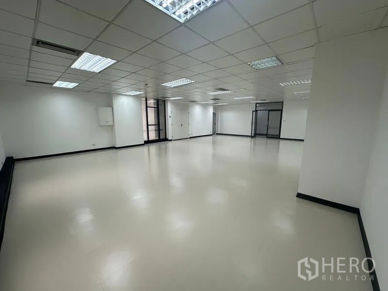 Office Space for rent - Angle view of open office showing glass entry and partition, smooth floors and recessed lighting.